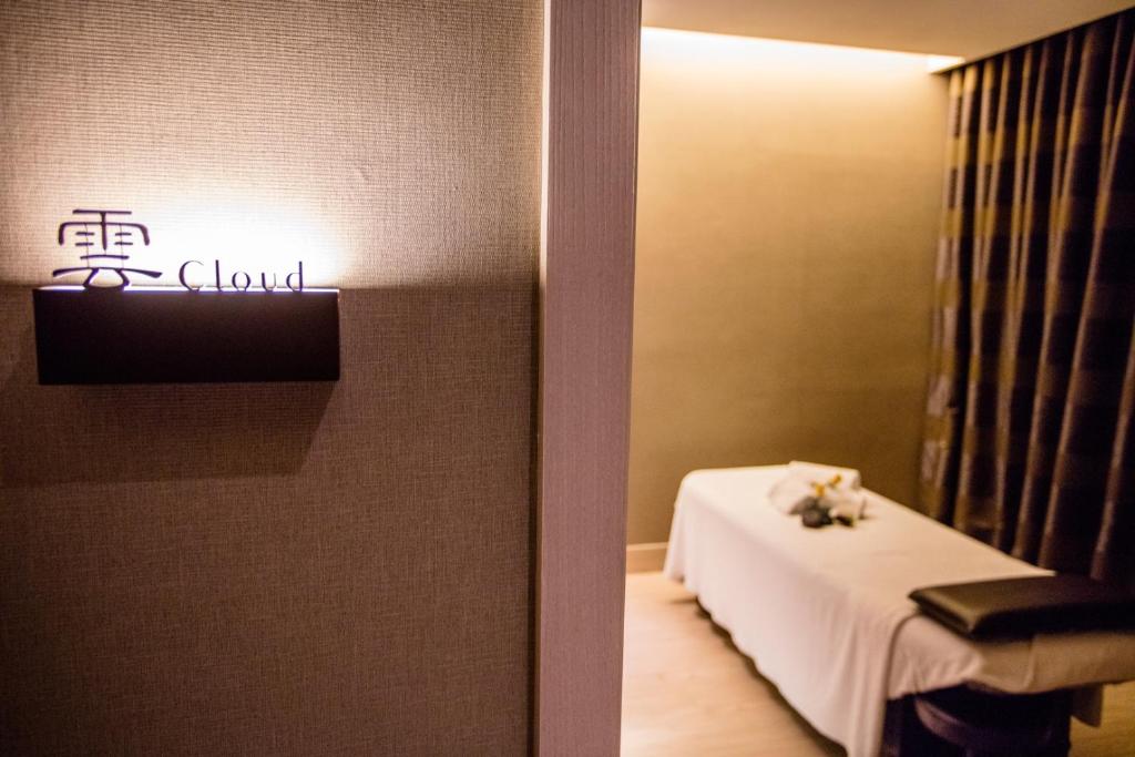 a room with a bed and a sign on the wall at Fullon Hotel Taoyuan Airport Access MRT A8 in Guishan