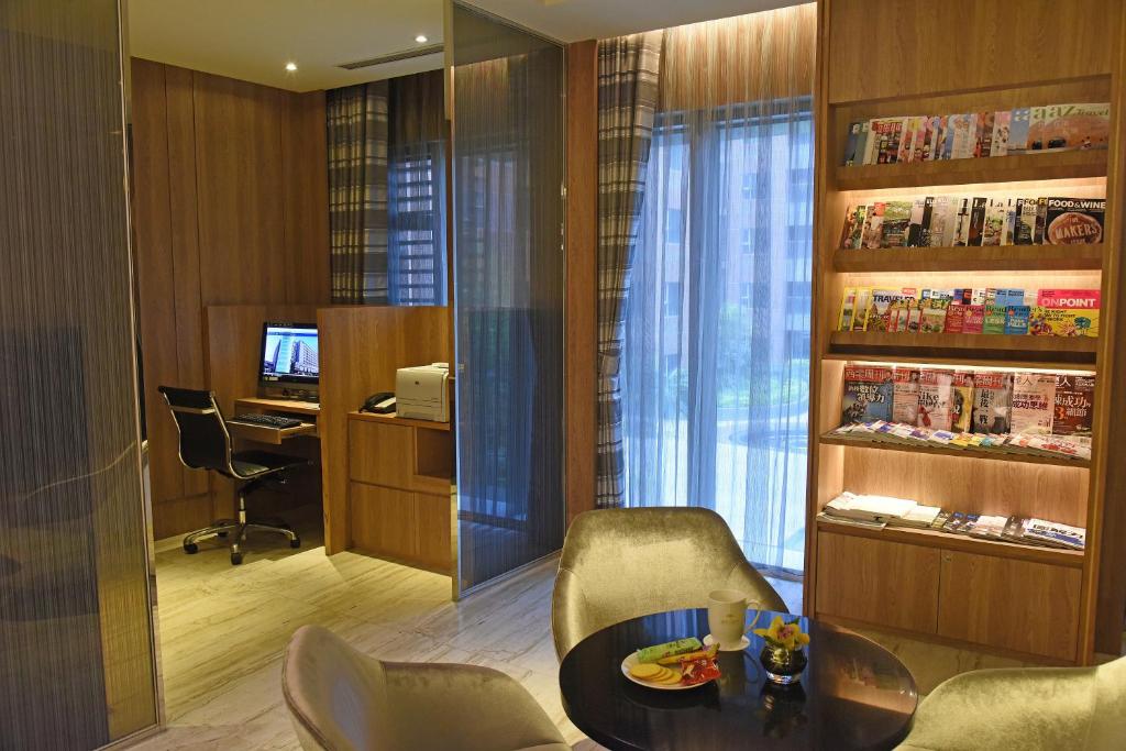 a room with a table and chairs and a desk at Fullon Hotel Taoyuan Airport Access MRT A8 in Guishan