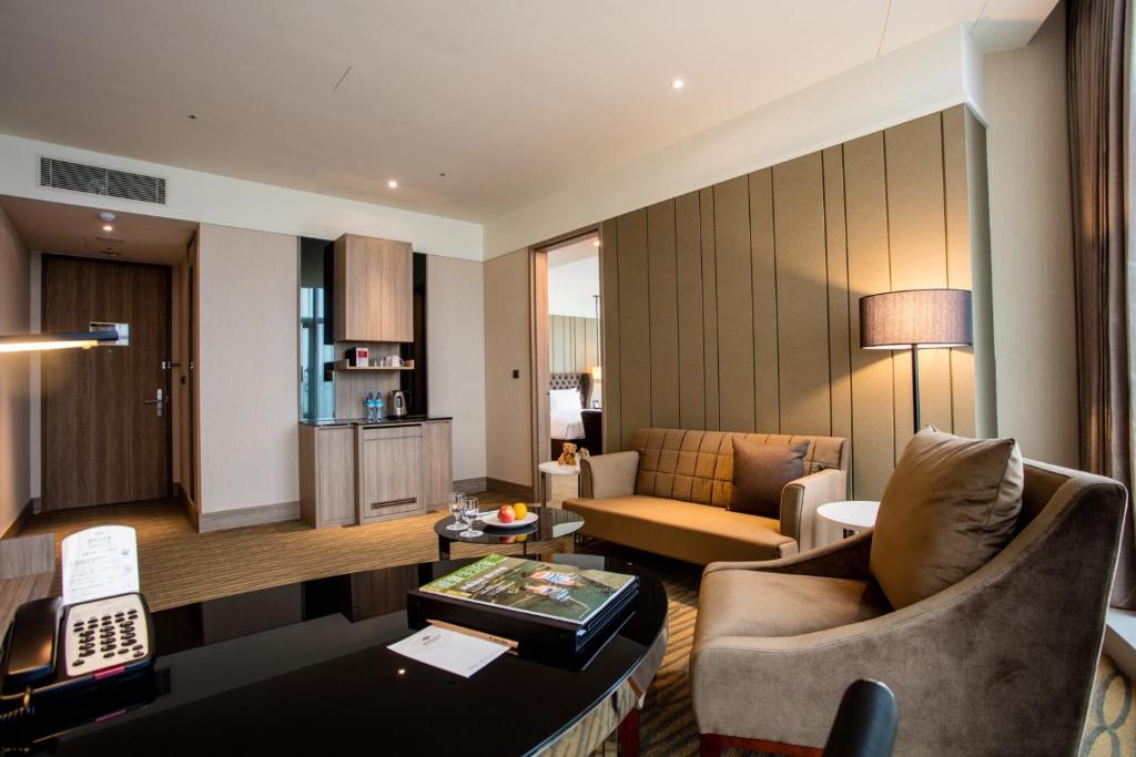 a living room with a couch and a table at Fullon Hotel Taoyuan Airport Access MRT A8 in Guishan