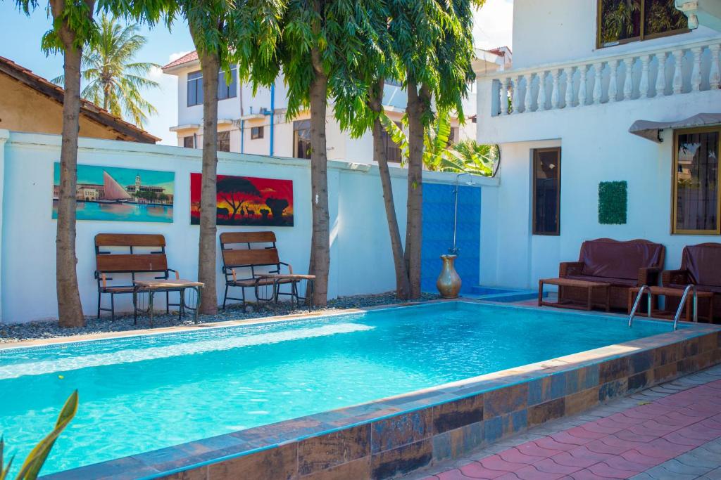 a swimming pool in front of a house at Mikocheni Condo Hotel & Apartments in Dar es Salaam