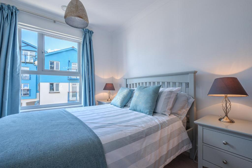 1 dormitorio con cama y ventana grande en The Point, en Exmouth