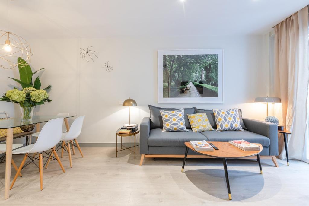 een woonkamer met een blauwe bank en een tafel bij Sophisticated brand new flat in Madrid
