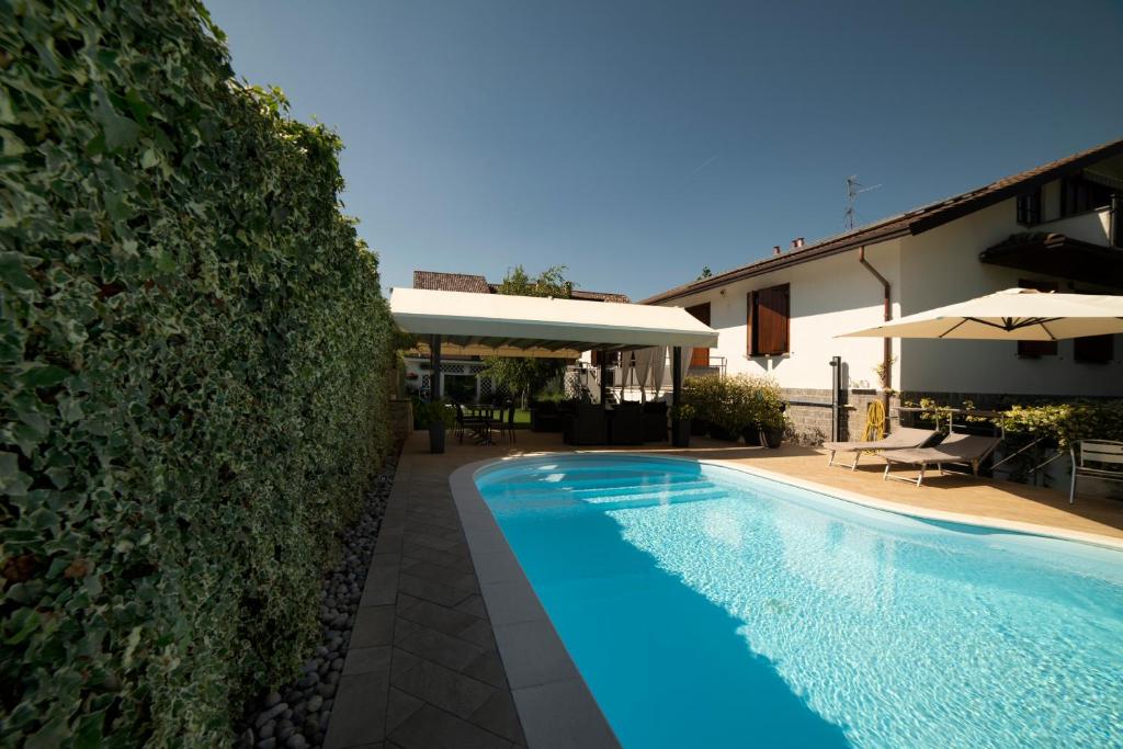 basen przed domem z żywopłotem w obiekcie Cascina36 B&B w mieście Pregnana Milanese