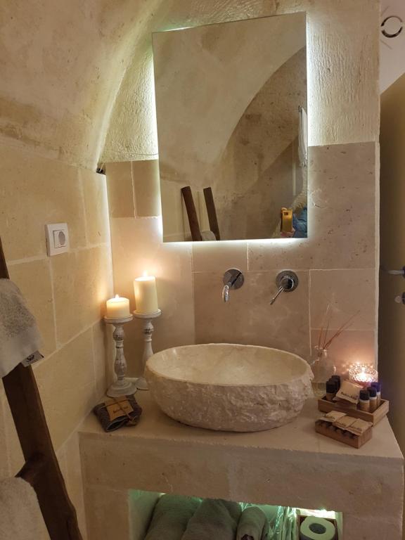 W łazience znajduje się duża kamienna umywalka i lustro. w obiekcie Le LUMINARIe Sassi w mieście Matera