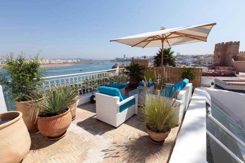 un balcón con sillas, sombrilla y plantas en LAU 04 Kasbah Sea View en Rabat