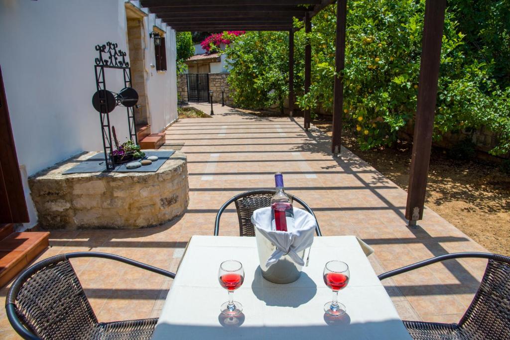 a table with wine glasses and a bottle on it at Douliana Villas in Douliana