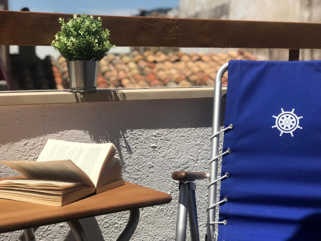 an open book sitting on a chair on a balcony at Lets Holidays Apartment Tossa Near Beach 2 in Tossa de Mar