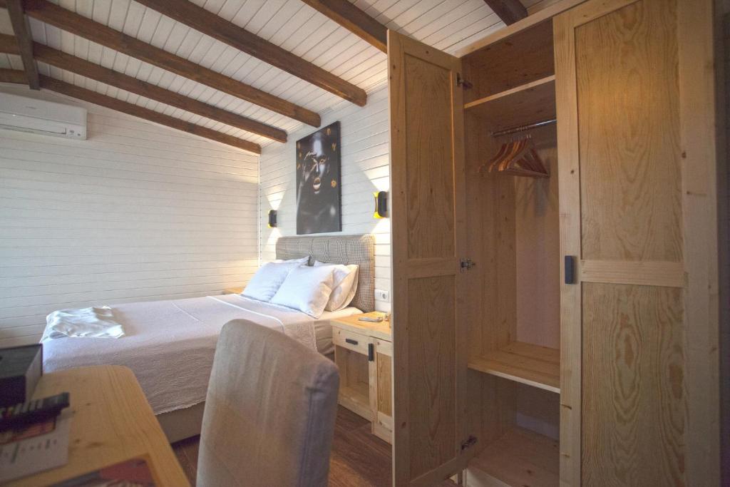 a small bedroom with a bed and a desk and a table at Sunset Villa Hotel in Kaş