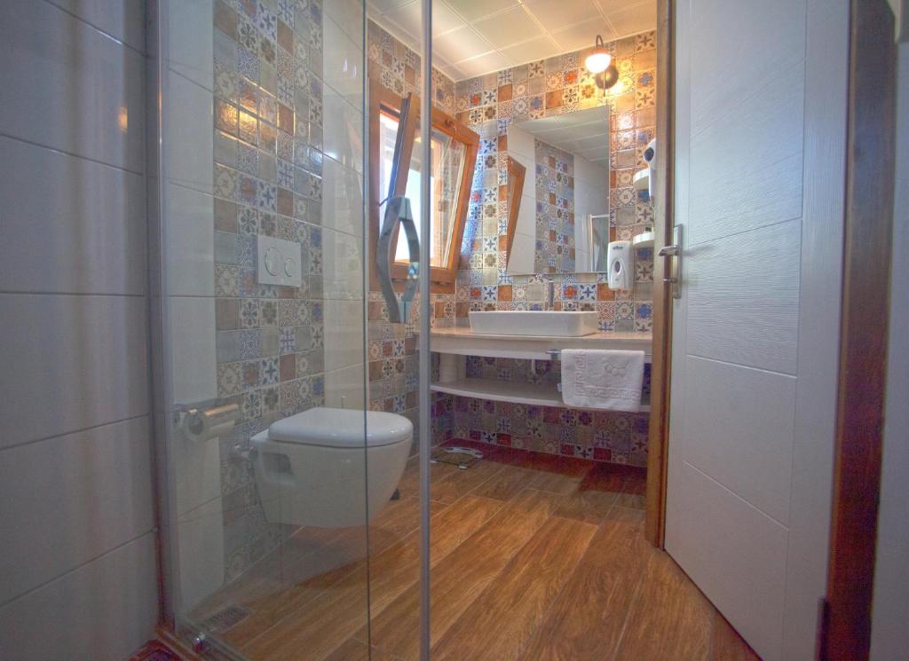 a bathroom with a shower and a toilet and a sink at Sunset Villa Hotel in Kaş