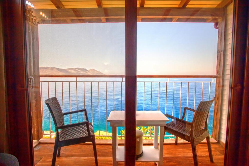 a table and chairs on a balcony with a view of the water at Sunset Villa Hotel in Kaş
