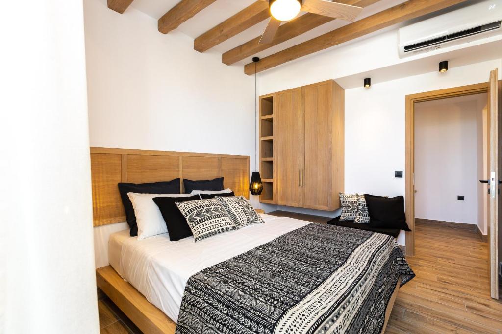 a bedroom with a large bed with black and white pillows at Theros in Rethymno Town
