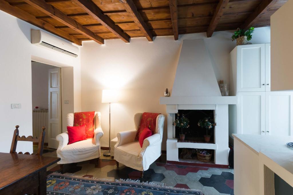 salon z 2 krzesłami i kominkiem w obiekcie TICINESE 59 APARTMENT w Mediolanie