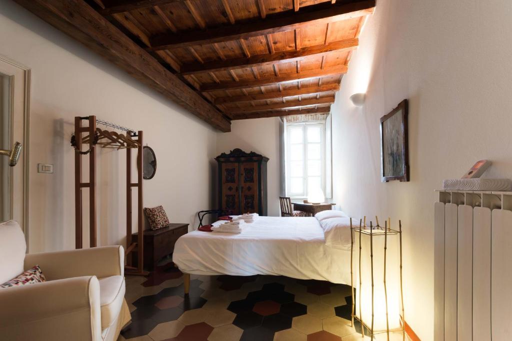 sypialnia z łóżkiem i krzesłem w pokoju w obiekcie TICINESE 59 APARTMENT w Mediolanie
