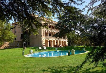 a large building with a swimming pool in the yard at Mas El Ricart in Malla