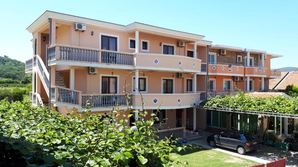 a building with a car parked in front of it at Rooms Ibrocevic in Ulcinj