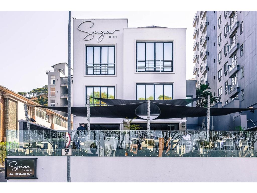 un edificio bianco con un ombrello nero davanti di Sugar Hotel a Città del Capo