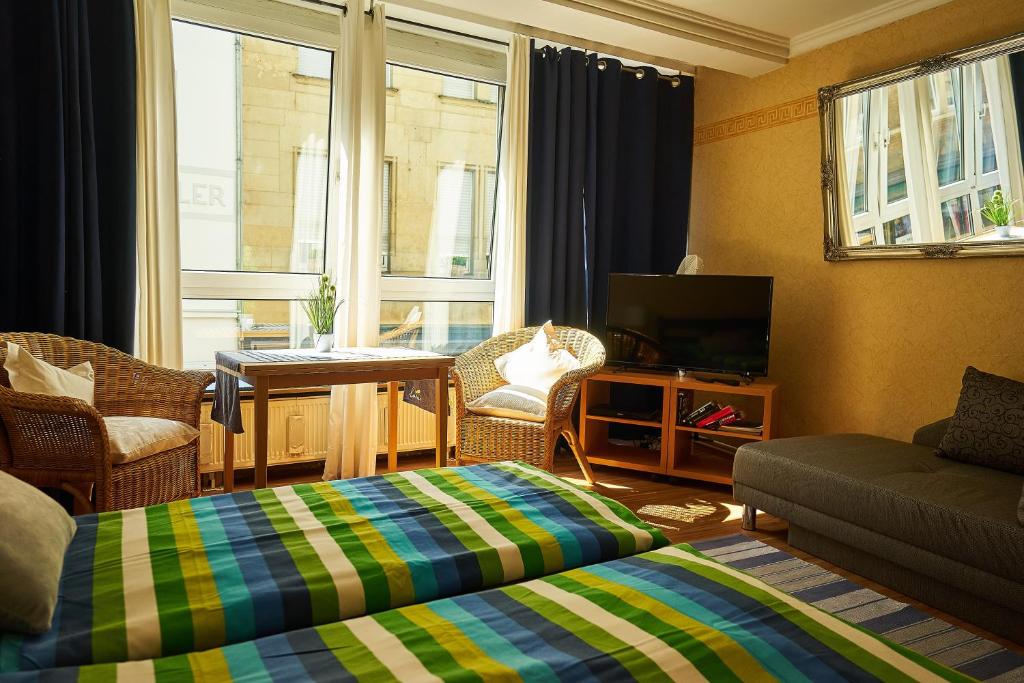 uma sala de estar com uma cama, um sofá e uma televisão em Perfectly Downtown / Mitten im Geschehen em Wiesbaden