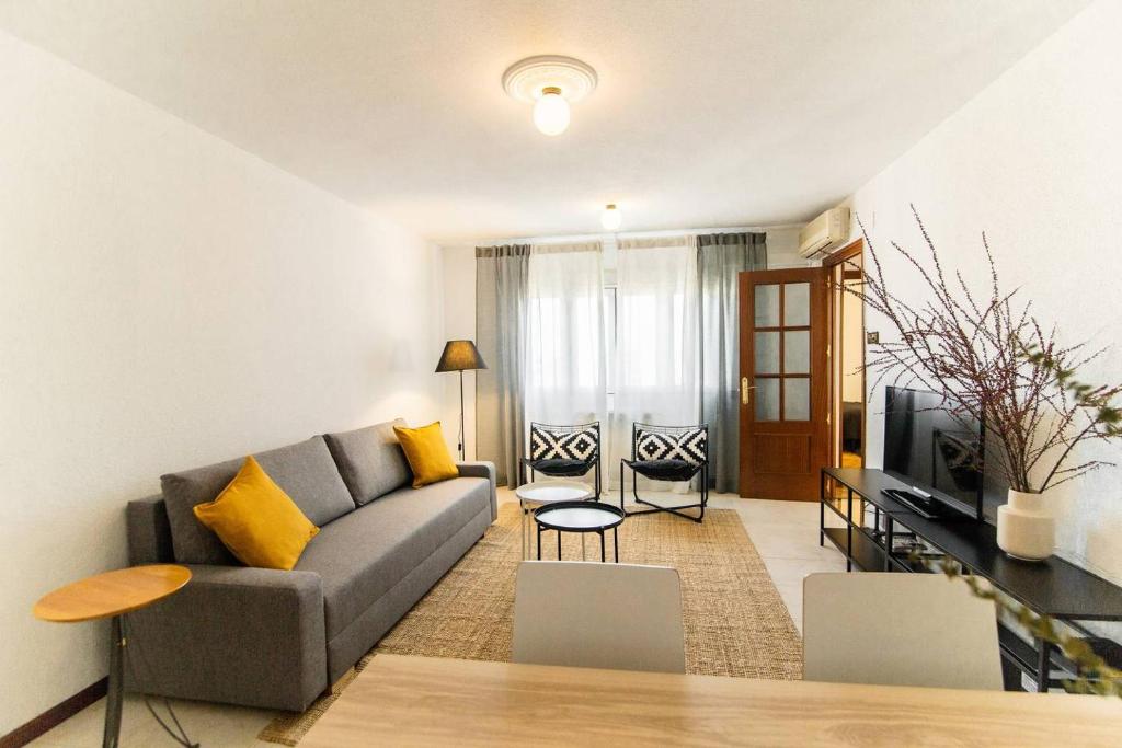 a living room with a couch and a tv at MODERN AND BRIGHT APARTMENT Plaza Elíptica -MAGIN in Madrid