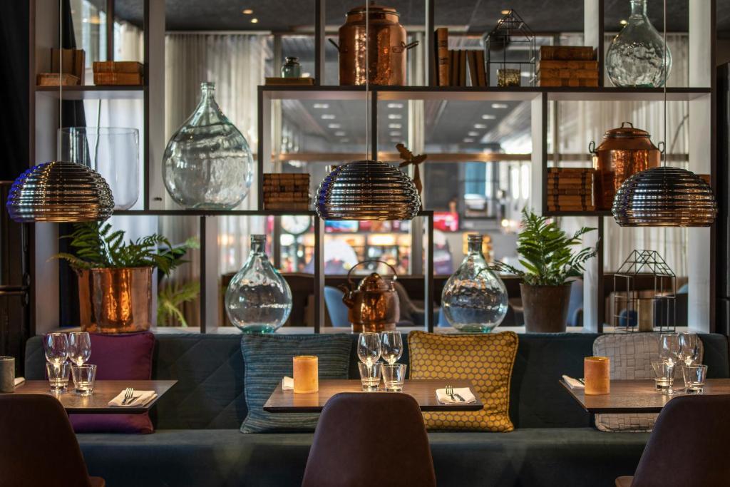 a restaurant with tables and chairs and glass vases at Quality Hotel Sundsvall in Sundsvall