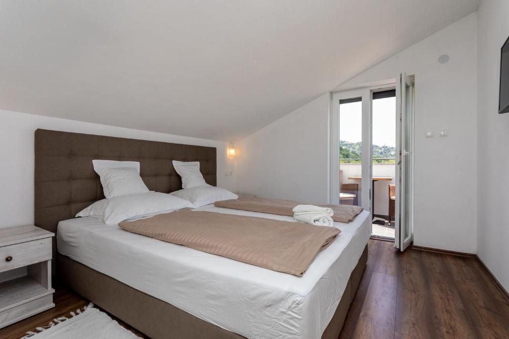 sypialnia z dużym łóżkiem i dużym oknem w obiekcie Bed & Breakfast Došen V w Bašce