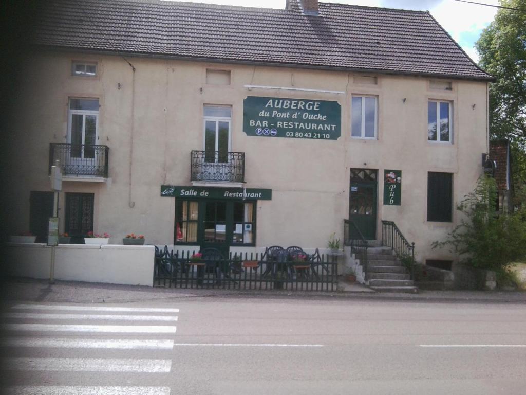 a building with tables and chairs in front of it at Auberge du Pont d'Ouche in Thorey-sur-Ouche