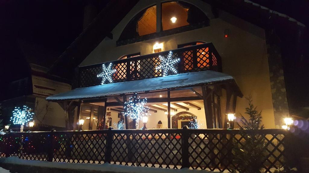 a building with christmas lights on the side of it at Casa Veveritelor in Predeluţ