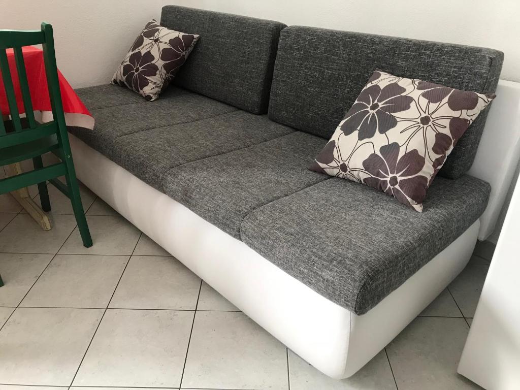 a couch with two pillows on it in a room at Stone House Center in Primošten