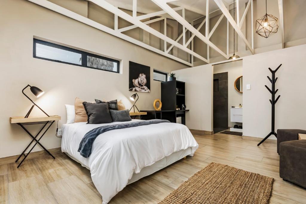 Habitación blanca con cama y sofá en 15 Port Elizabeth Country Getaway Deer Park estate15 en Puerto Elizabeth