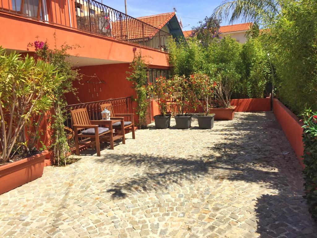 een patio met een tafel, stoelen en planten bij Villa du Cros in Cagnes-sur-Mer