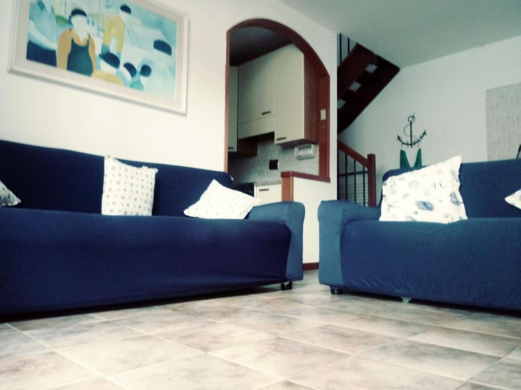 a living room with two blue couches and a staircase at Lovely Grado in Grado