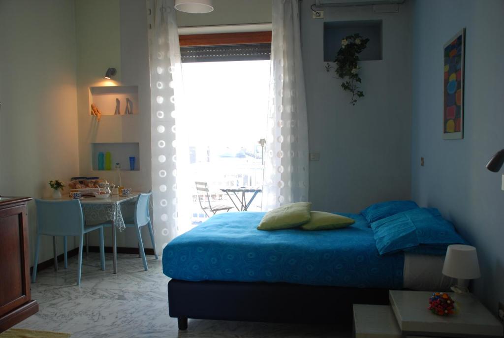 Schlafzimmer mit einem Bett, einem Tisch und einem Fenster in der Unterkunft Latt e Liett in Neapel