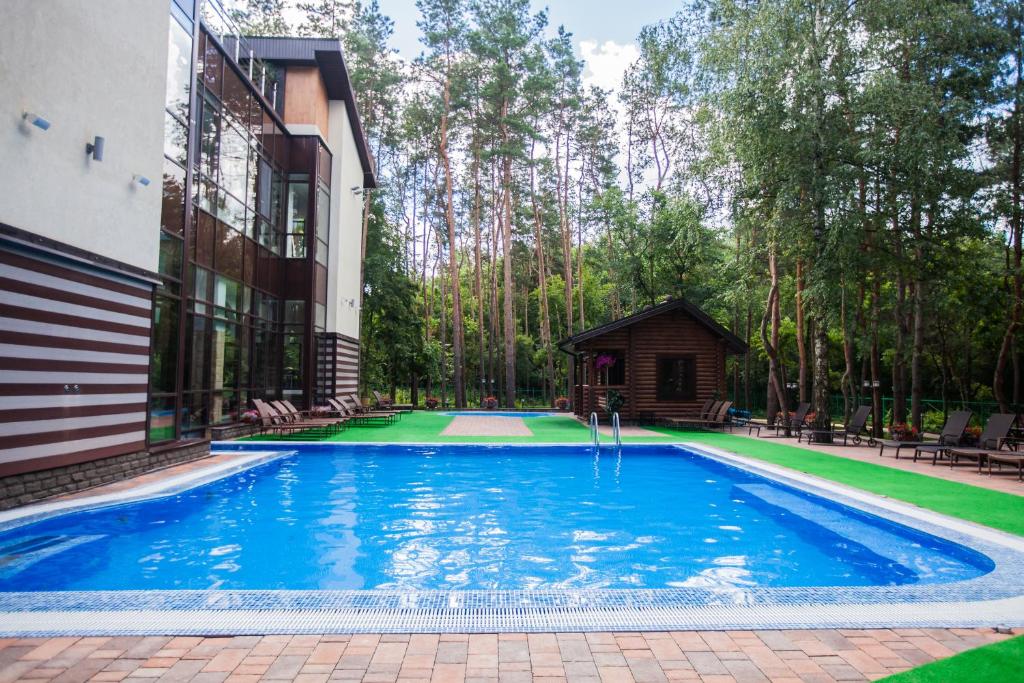 a swimming pool in a yard next to a building at Park-Hotel Europe in Belgorod