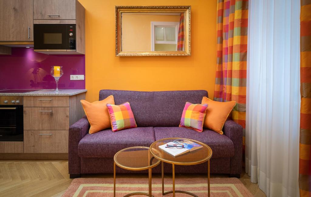 ウィーンにあるアパートメント-ホテル アン デル リエメルガセの紫色のソファとテーブル付きのリビングルーム
