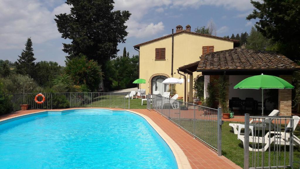 a swimming pool in front of a house at AGRITURISMO IL PINO - APPARTAMENTO QUERCE in Gambassi Terme