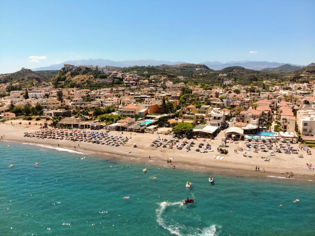 a beach with a bunch of people in the water at Athina Suites Luxury Suites Near The Sea Platanias in Platanias
