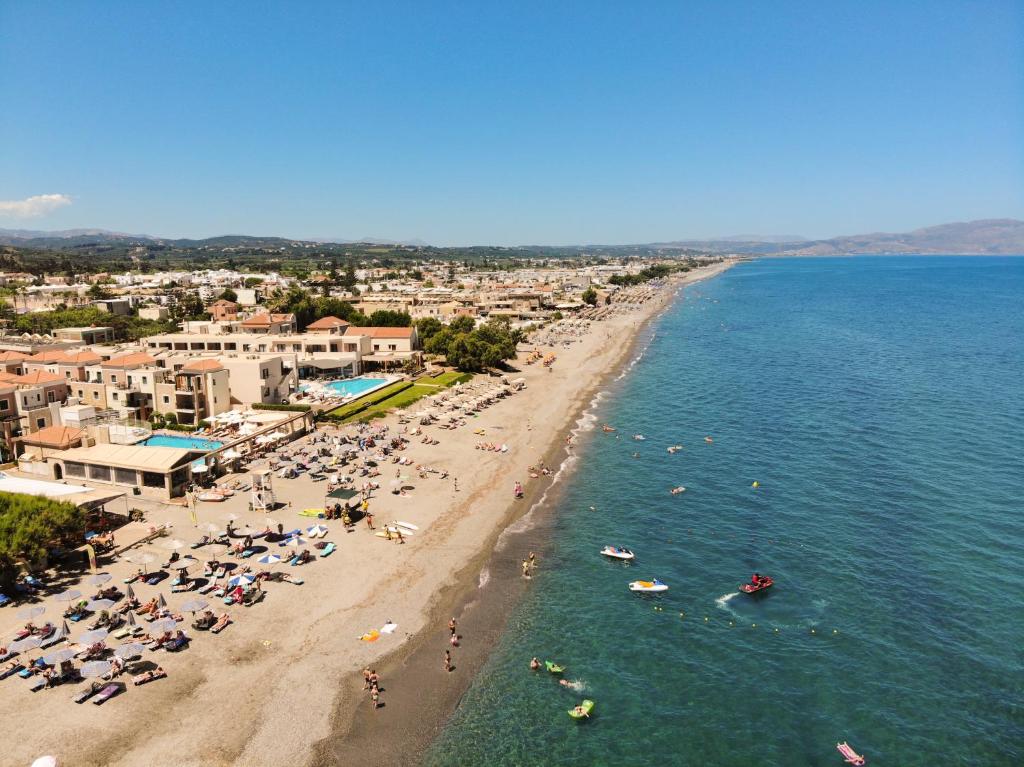 an aerial view of a beach with people in the water at Athina Suites Luxury Suites Near The Sea Platanias in Platanias