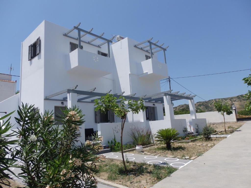 un edificio blanco con árboles delante de él en Skyros Koxilas Studios en Esciros