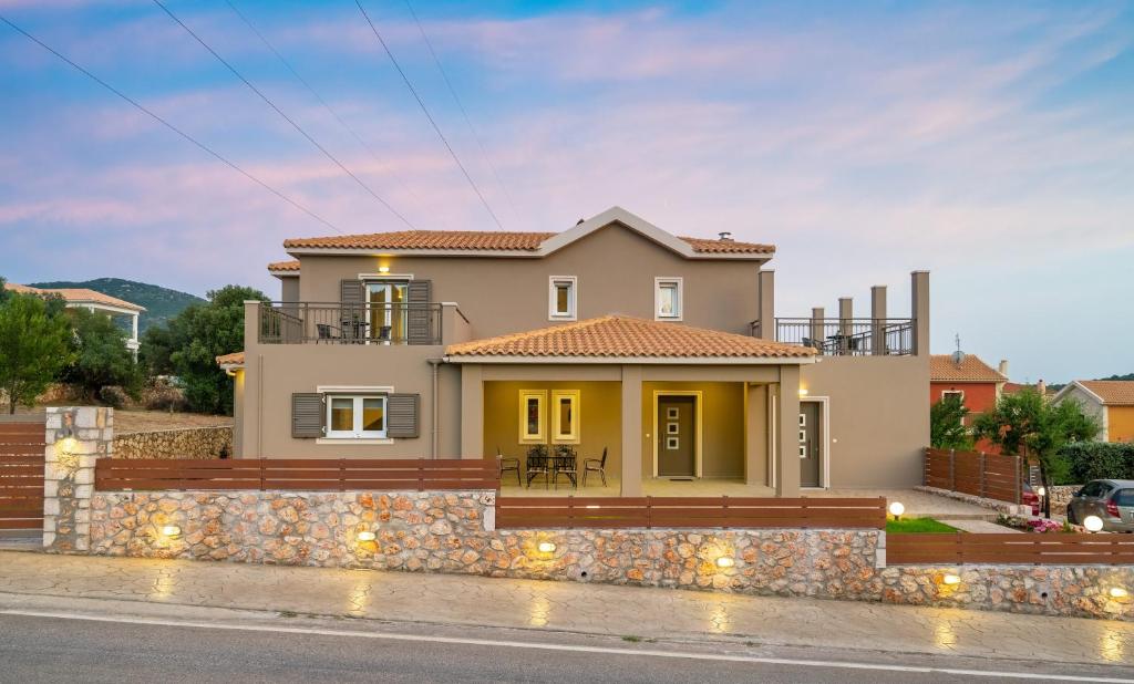 a yellow house with a stone wall at Alexandra's Residence in Kefallonia