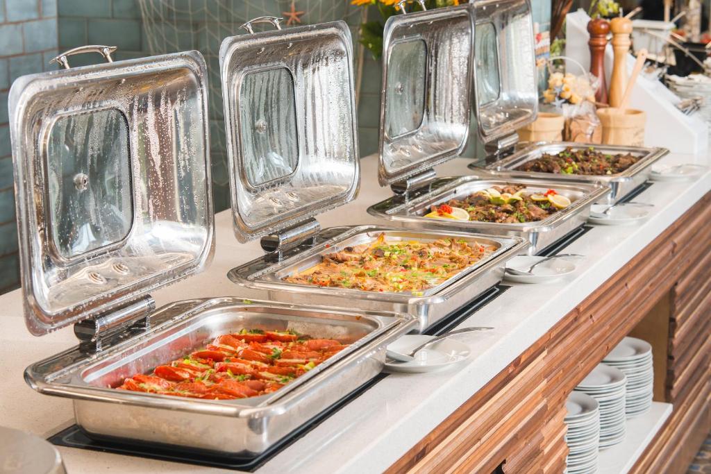 a row of trays of food on a buffet line at Sunrise Blue Magic Resort - All Inclusive in Obzor