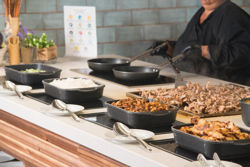 a buffet with several dishes of food on a counter at Sunrise Blue Magic Resort - All Inclusive in Obzor