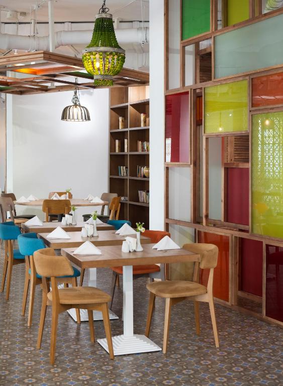 a dining room with tables and chairs and bookshelves at Sunrise Blue Magic Resort - All Inclusive in Obzor