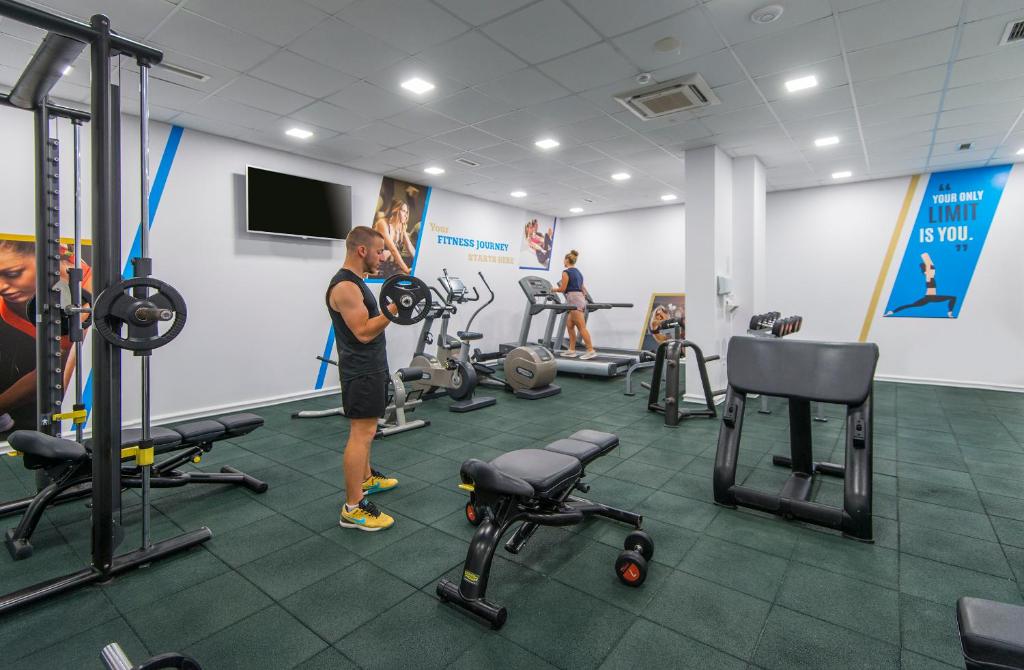 a man standing in a gym with weights at Sunrise Blue Magic Resort - All Inclusive in Obzor