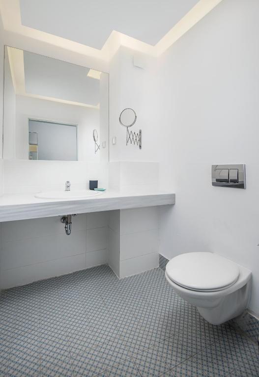 a white bathroom with a toilet and a sink at Sunrise Blue Magic Resort - All Inclusive in Obzor