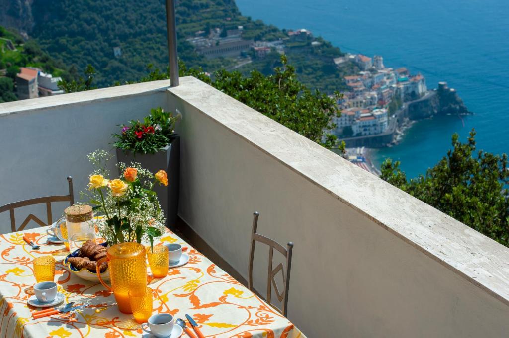 a table on a balcony with a view of the ocean at Prima Luce in Amalfi