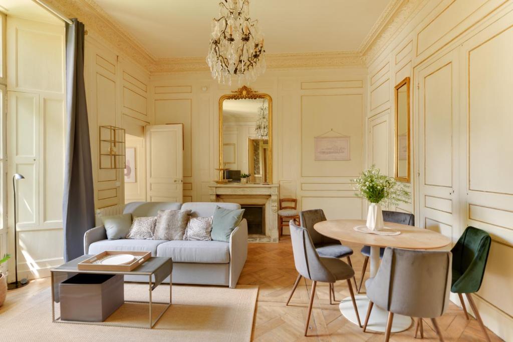 een woonkamer met een bank en een tafel bij La Suite de Pauline - Appt au coeur de Rennes in Rennes