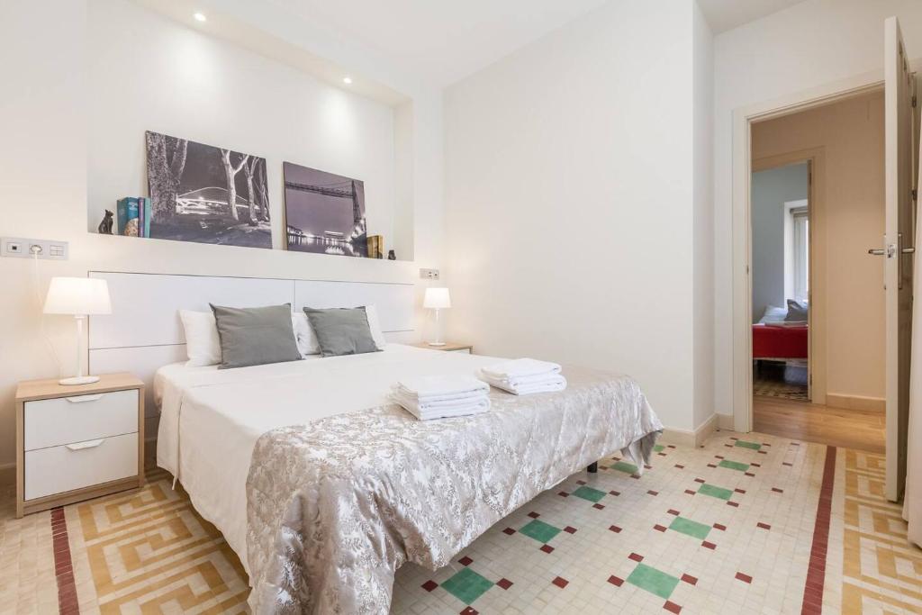 Un dormitorio blanco con una cama grande y una mesa en T2, Tirso de Molina, apartamento luminoso y tranquilo, en Sevilla
