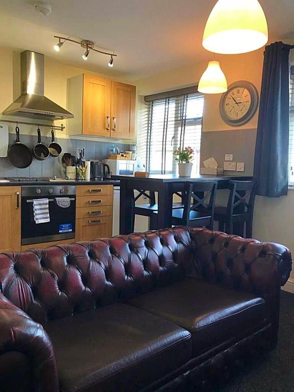 uma sala de estar com um sofá de couro numa cozinha em Coleman Apartment em Wolverhampton