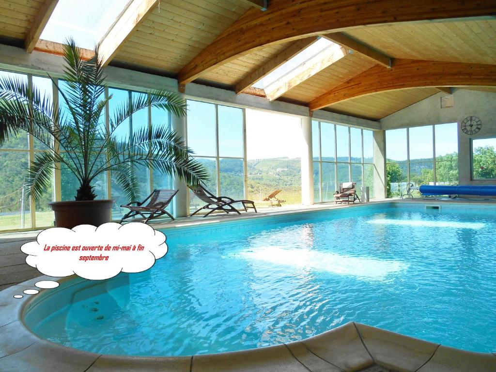 una gran piscina en una habitación con ventanas en Chalet Relais du Temple, en Mornans