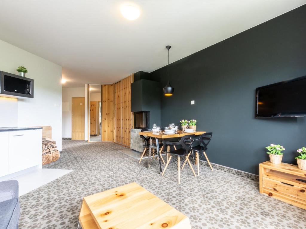 cocina y sala de estar con mesa y sillas en VacationClub – Cristal Resort Apartament 414, en Szklarska Poręba
