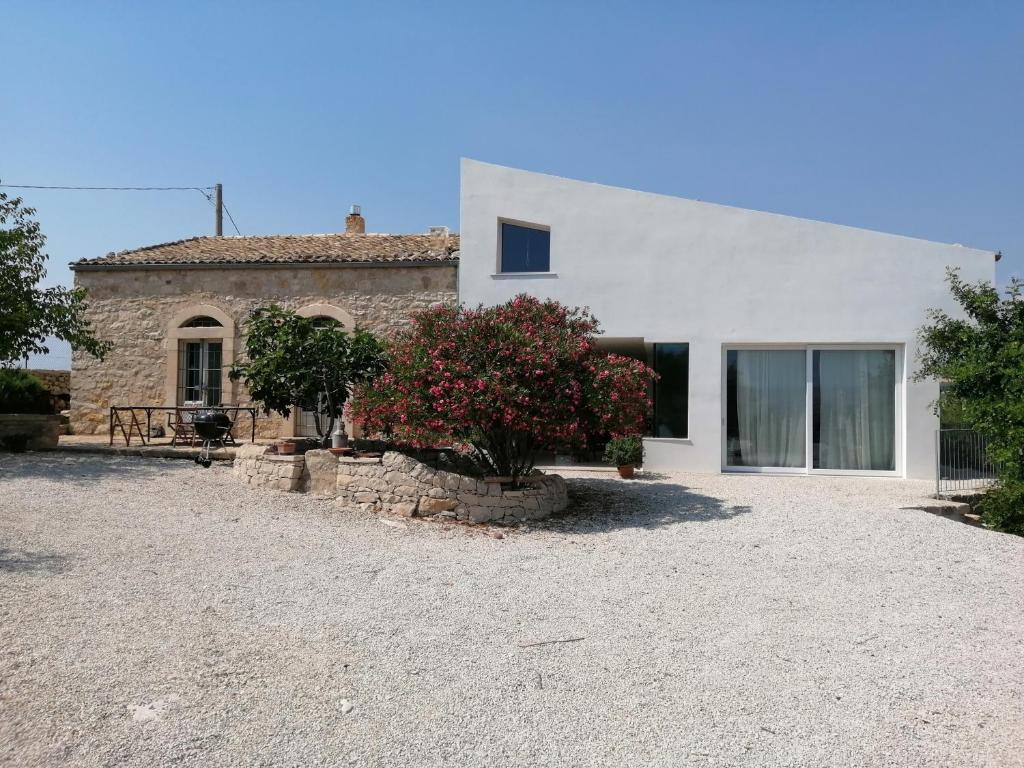 a white house with a tree in front of it at Poggio del Gallo in Chiaramonte Gulfi